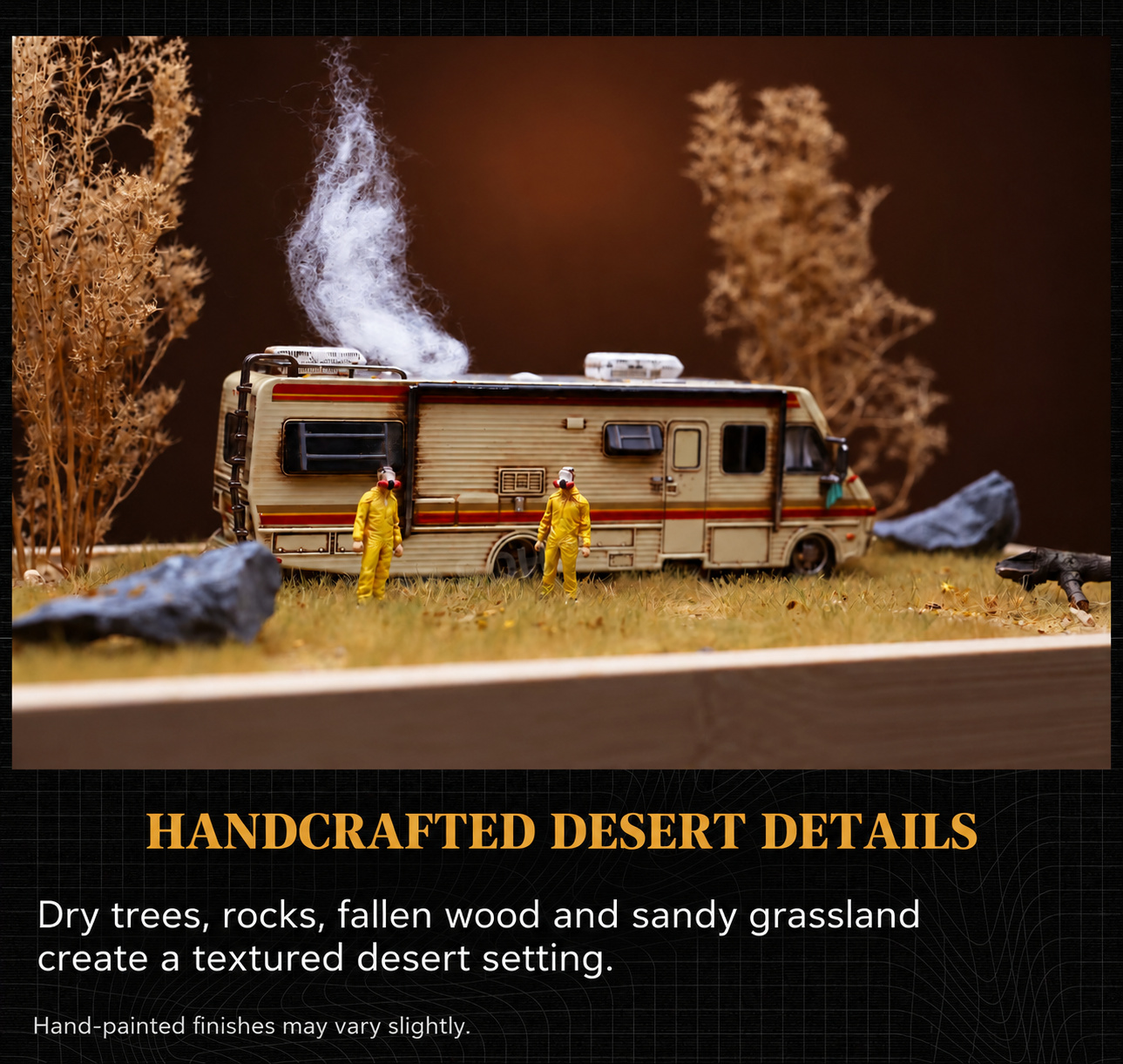 Close photograph of the desert-tree scene showing two hazmat figures, weathered RV, dry trees, rocks and fallen wood